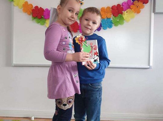 Chłopiec wręcza dziewczynce laurkę