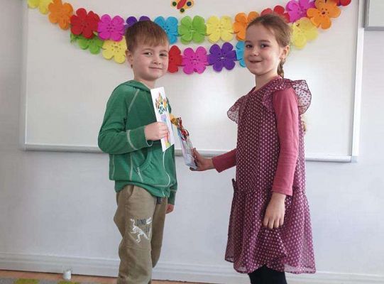 Chłopiec wręcza dziewczynce laurkę