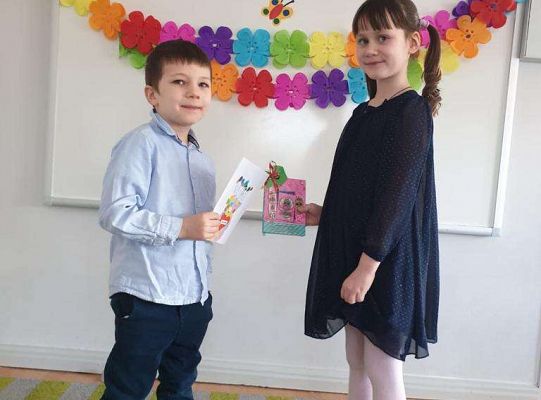 Chłopiec wręcza dziewczynce laurkę