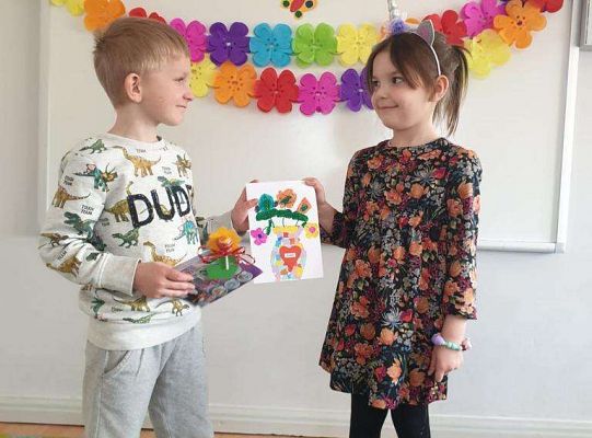 Chłopiec wręcza dziewczynce laurkę