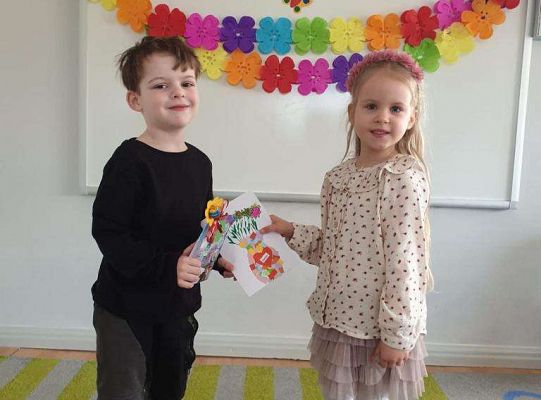 Chłopiec wręcza dziewczynce laurkę