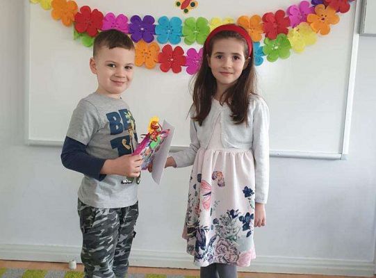 Chłopiec wręcza dziewczynce laurkę