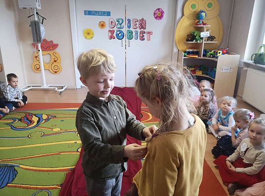 Chłopiec przykleja numer startowy do wyborów Miss