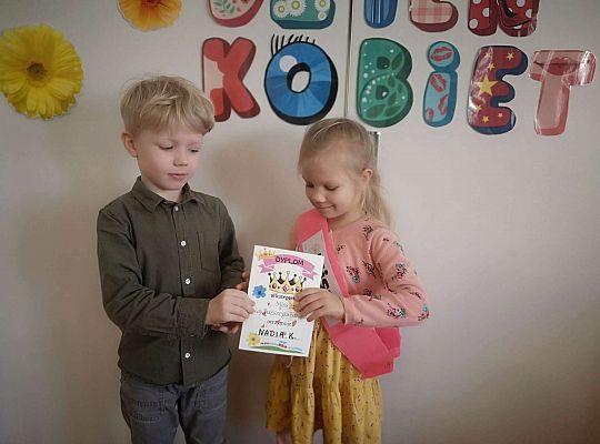 Chłopiec wręcza dyplom małej Miss