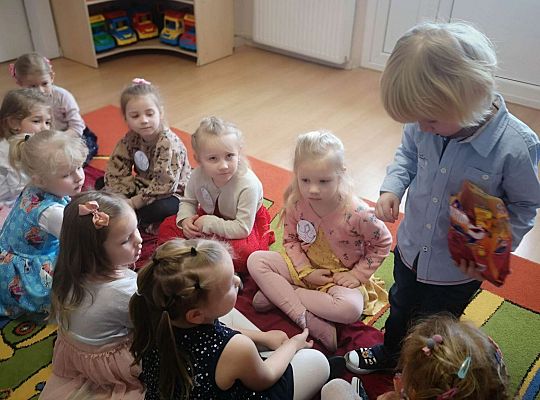 Chłopiec częstuje dziewczynki słodyczami