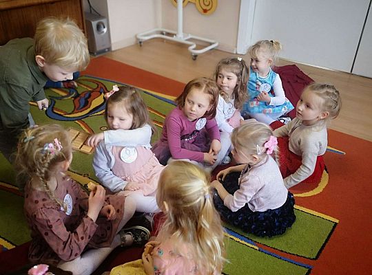 Chłopiec częstuje dziewczynki słodyczami