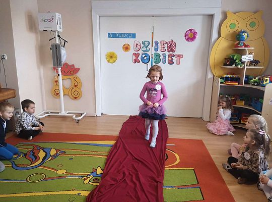 Dziewczynka idzie po czerwonym dywanie