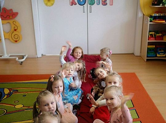 Dziewczynki siedzą na czerwonym dywanie