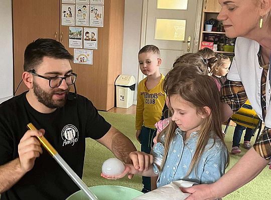 Dzieci trzymają bańki z dymem