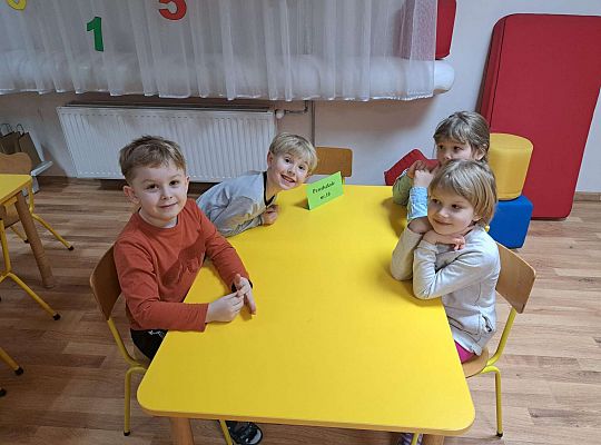 Czwórka dzieci siedzi przy stole