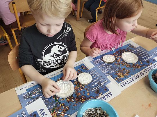 Dzieci układają bursztyn i muszelki