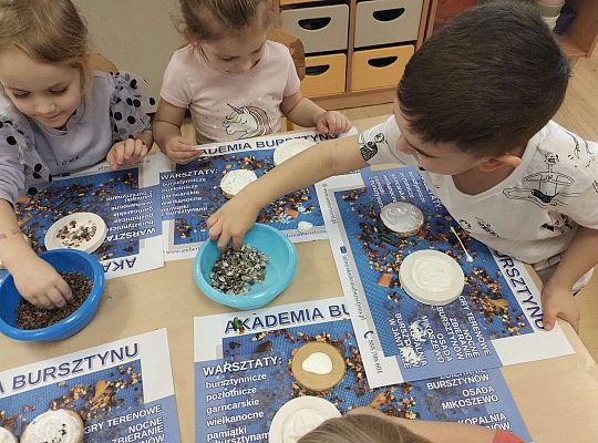 Dzieci układają bursztyn i muszelki