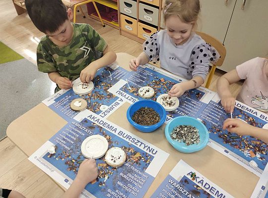 Dzieci układają bursztyn i muszelki