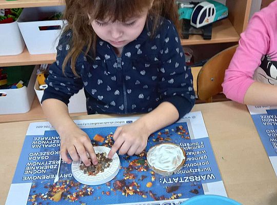 Dzieci układają bursztyn i muszelki