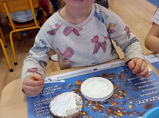 Dzieci układają bursztyn i muszelki