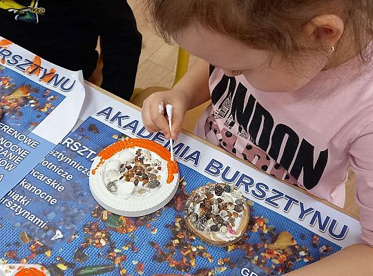 Dzieci układają bursztyn i muszelki