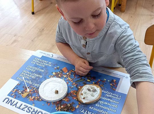 Dzieci układają bursztyn i muszelki