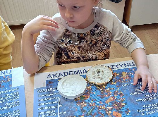 Dzieci układają bursztyn i muszelki