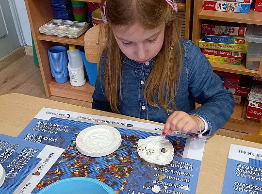 Dzieci układają bursztyn i muszelki