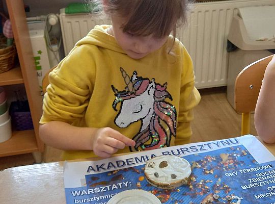 Dzieci układają bursztyn i muszelki