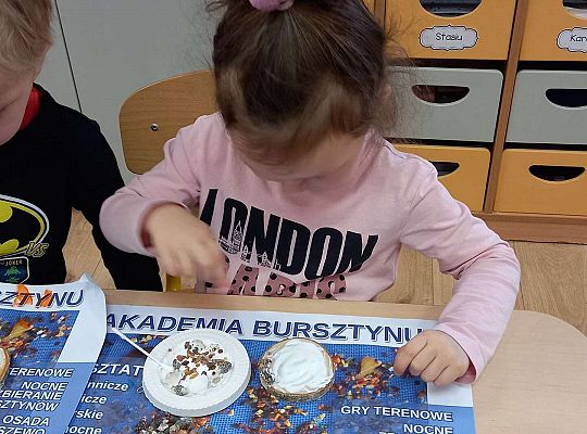 Dzieci układają bursztyn i muszelki