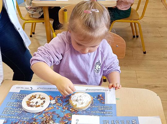 Dzieci układają bursztyn i muszelki