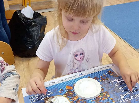 Dzieci układają bursztyn i muszelki