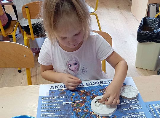 Dzieci układają bursztyn i muszelki