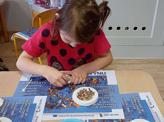 Dzieci układają bursztyn i muszelki