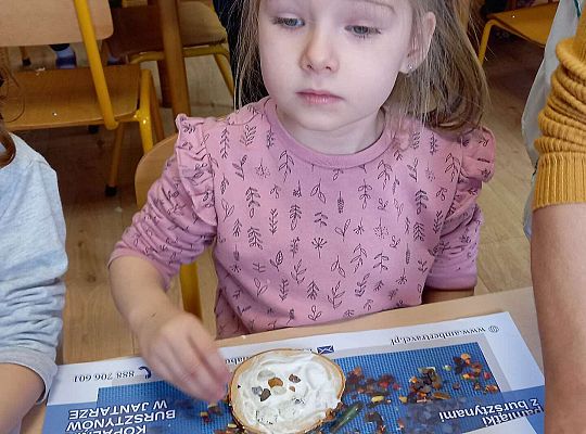 Dzieci układają bursztyn i muszelki