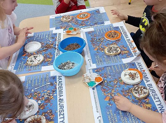 Dzieci układają bursztyn i muszelki