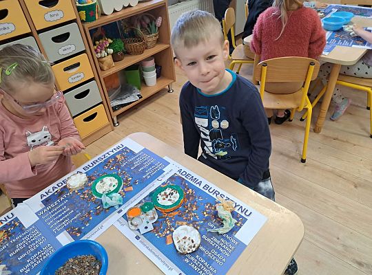 Dzieci wykonują prace z bursztynem