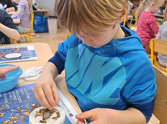 Chłopiec wykonuje prace z bursztynem