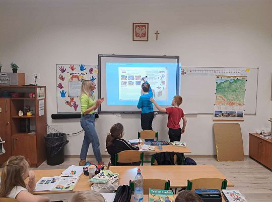 Dzieci wykonują zadania na tablicy multimedialnej