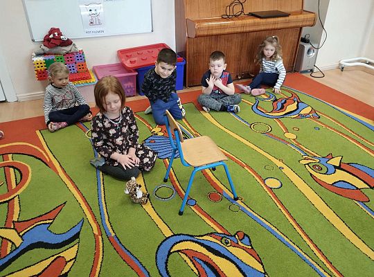 Dzieci ćwiczą położenie kotka względem krzesła