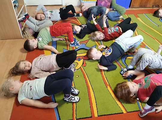 Dzieci wykonują ćwiczenia gimnastyczne