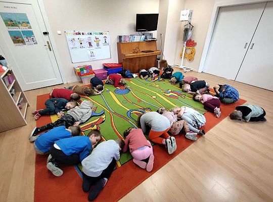 Dzieci wykonują ćwiczenia gimnastyczne