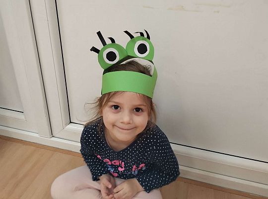 Dziewczynka z obręczą żabki na głowie
