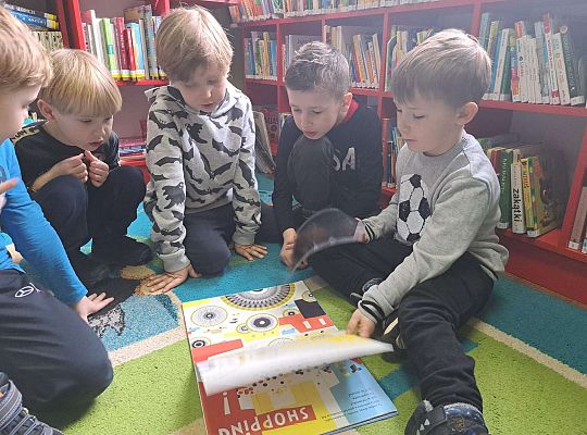 Chłopcy ogladają książeczkę