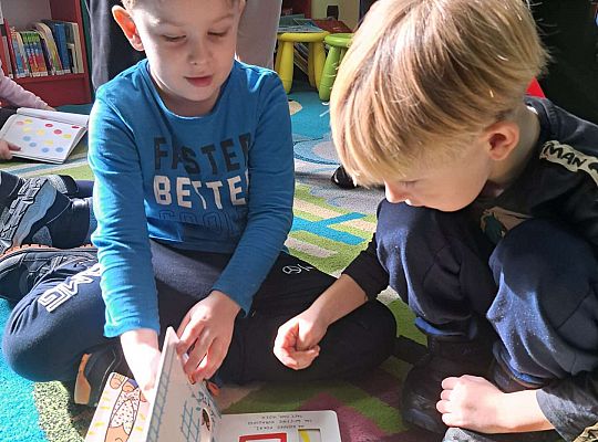 Chłopcy oglądają książeczkę