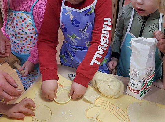 Dzieci wykrajają ciasto w kształcie jajka na mazurki