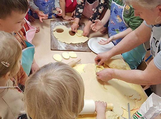 Dzieci wykrajają ciasto w kształcie jajka na mazurki