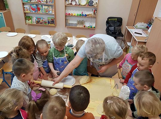 Dzieci wykrajają ciasto w kształcie jajka na mazurki