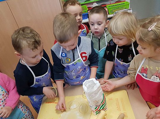 Dzieci wykrajają ciasto w kształcie jajka na mazurki