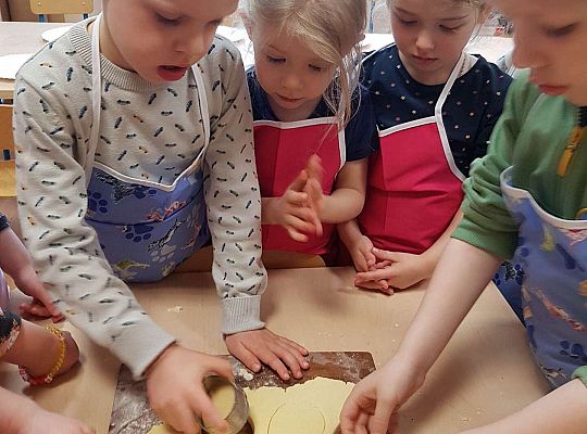 Dzieci wykrajają ciasto w kształcie jajka na mazurki