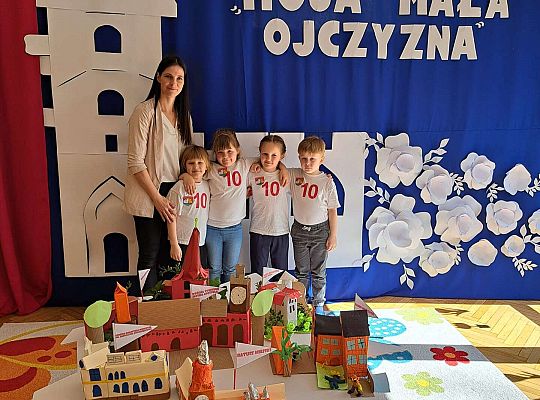 Dzieci z wychowawczynią na tle dekoracji