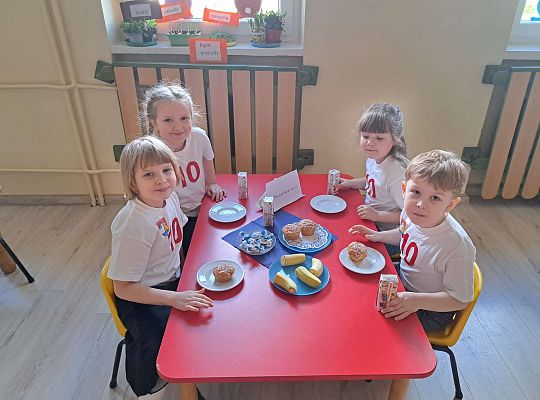 Dzieci przy stole z poczęstunkiem