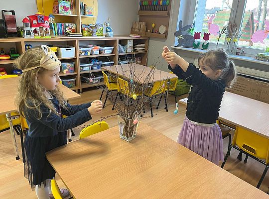 Dzieci wieszają jajeczka na gałązkach