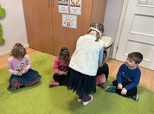 Dziewczynka częstuje dzieci czekoladowymi jajkami