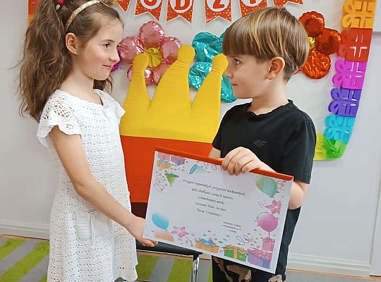 Chłopiec wręcza album solenizantce